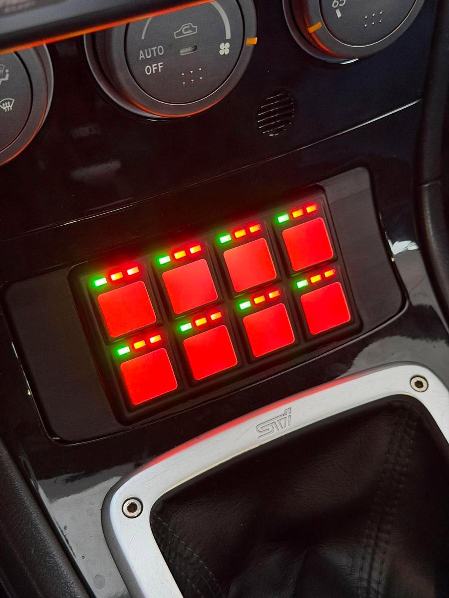 Haltech CAN keypad mounted in the center console of a 2005-2007 Subaru WRX, backlit red