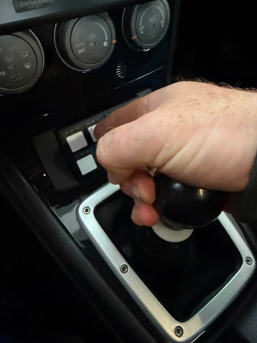 Driver's hand on the shifter with the keypad within thumb reach